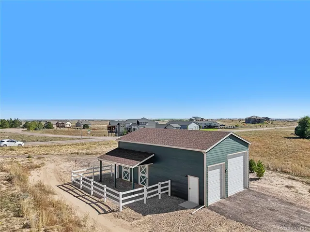 a view of a dry yard with wooden fence