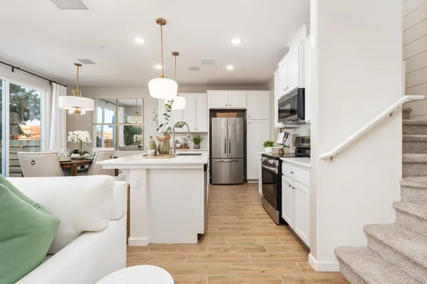 a kitchen with stainless steel appliances kitchen island granite countertop a refrigerator a oven a sink and a refrigerator