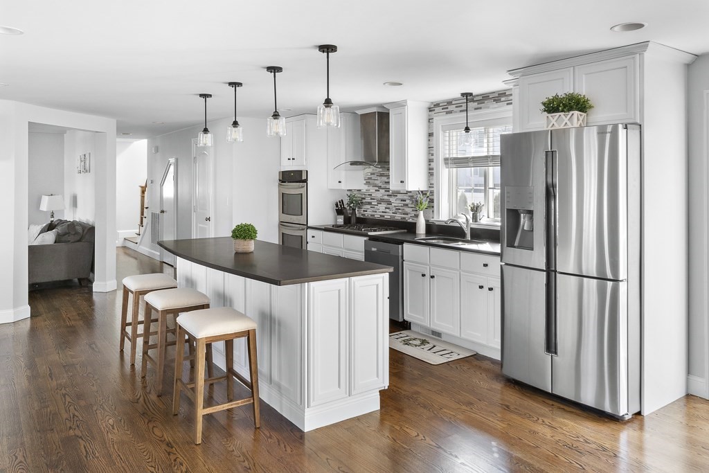 2 Willow Avenue Danvers, MA 01923 - Photo 3 of 42 a kitchen with stainless steel appliances granite countertop a refrigerator a sink dishwasher a stove and a dining table with wooden floor