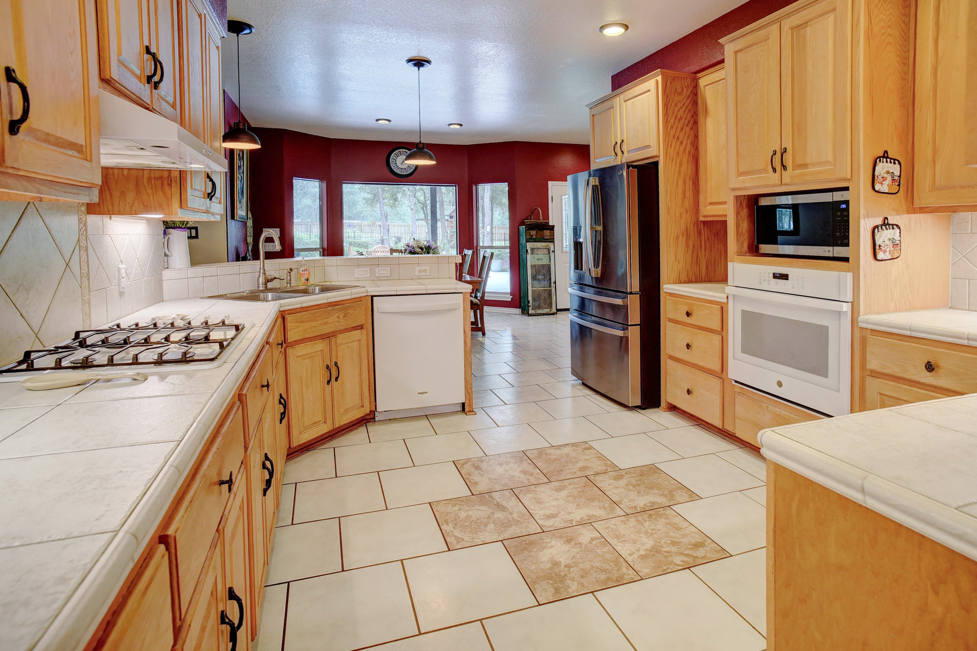 147 Spring Meadow Road Bastrop, TX 78602 - Photo 8 of 40 Spacious kitchen featuring light wood cabinetry with dark hardware, a gas cooktop, built-in oven, and a built-in microwave