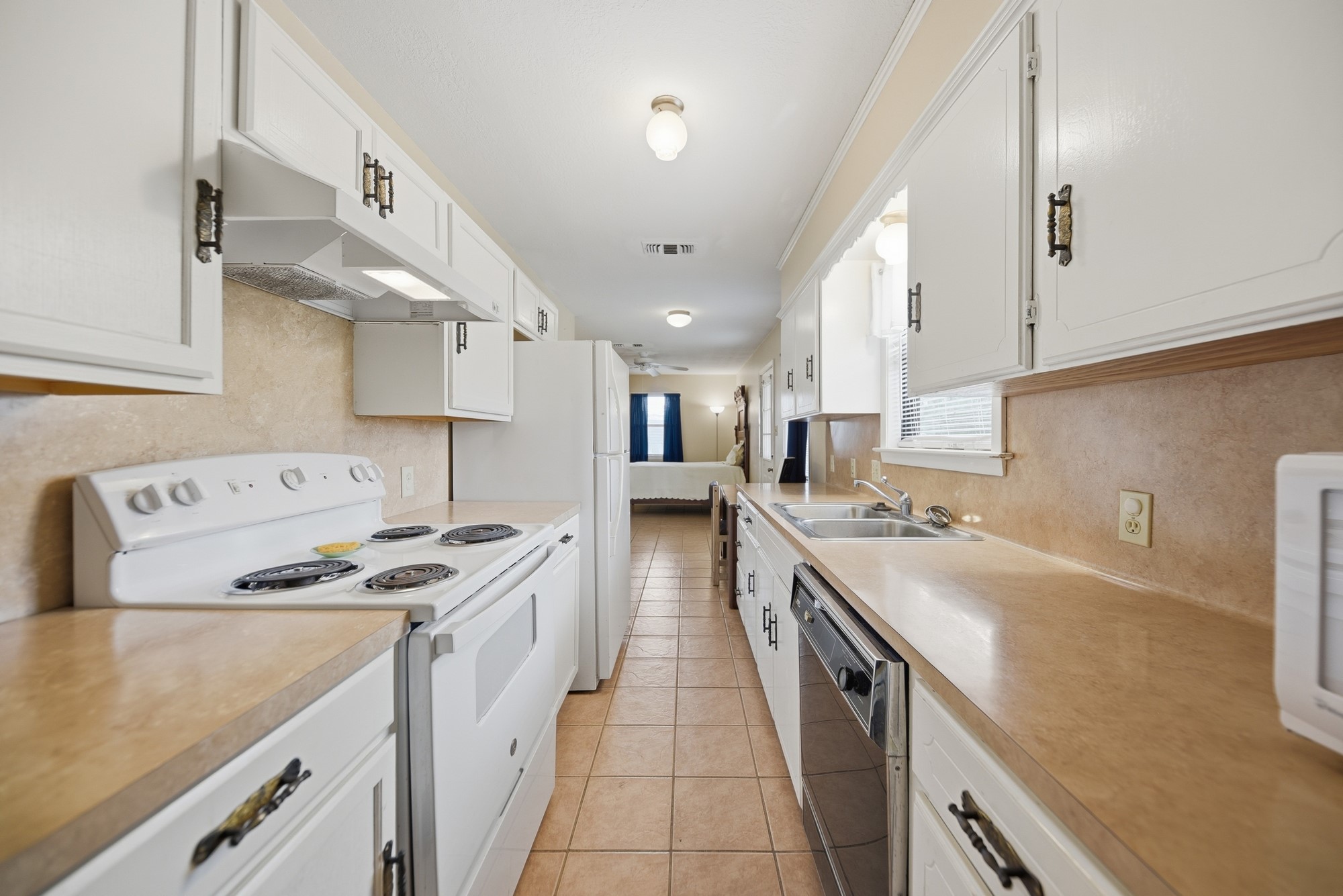 1406 Key Street Brenham, TX 77833 - Photo 41 of 50 Guest Suite A - Bright, clean galley kitchen with white cabinets, neutral countertops, and a functional, light-filled layout.