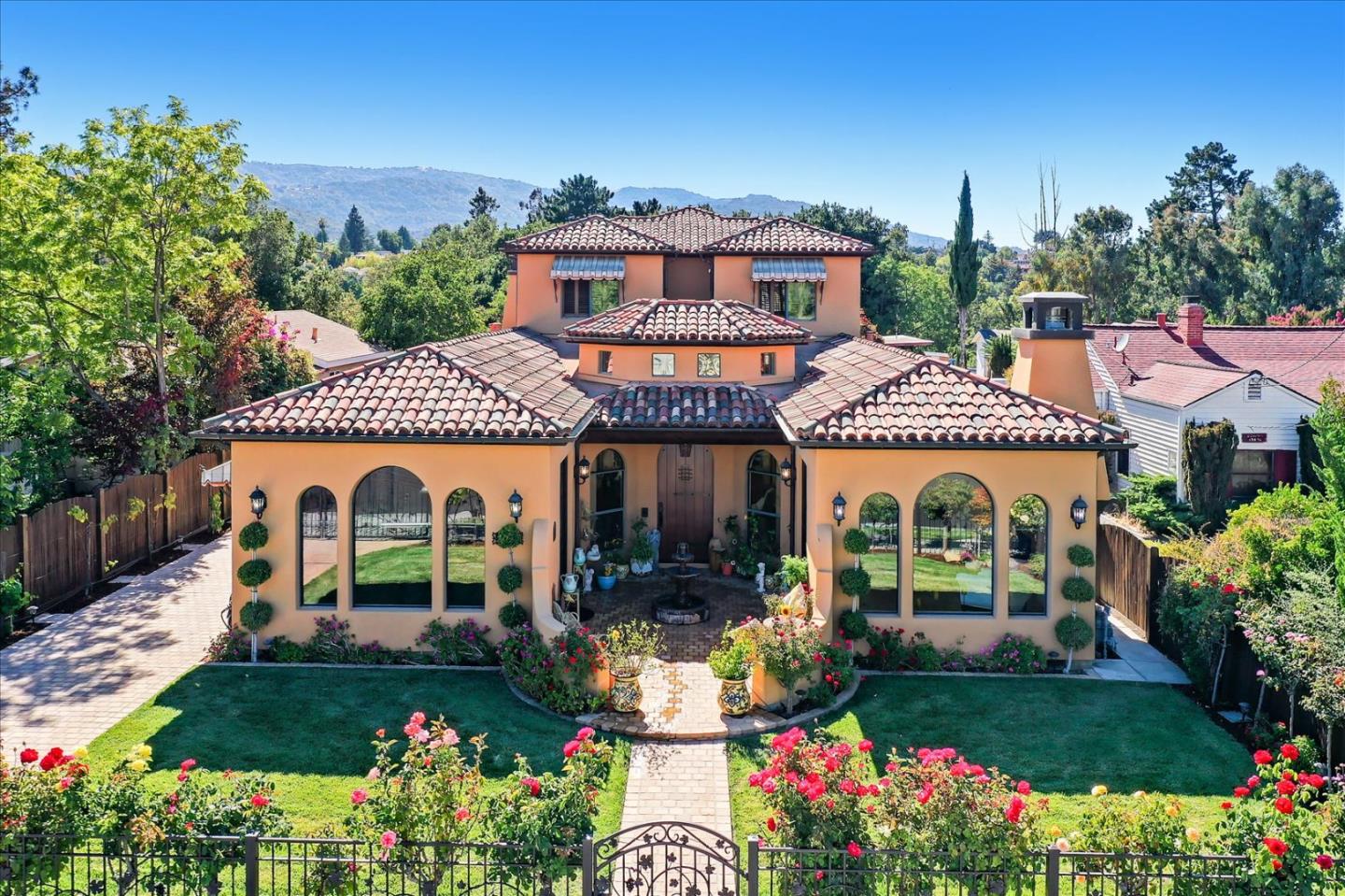 a view of a white house with a large garden