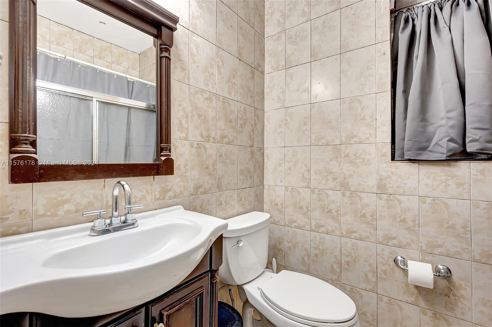 351 Southwest 22nd Road Miami, FL 33129 - Photo 17 of 27 a bathroom with a sink a toilet and a mirror