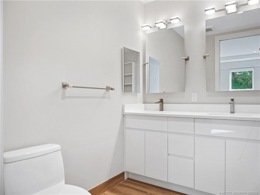 41 Southwest Seminole Street, Unit 208 Stuart, FL 34994 - Photo 27 of 46 a bathroom with a double vanity sink and a mirror