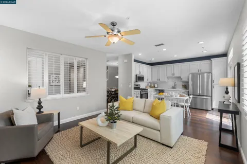 a living room with furniture kitchen view and a window