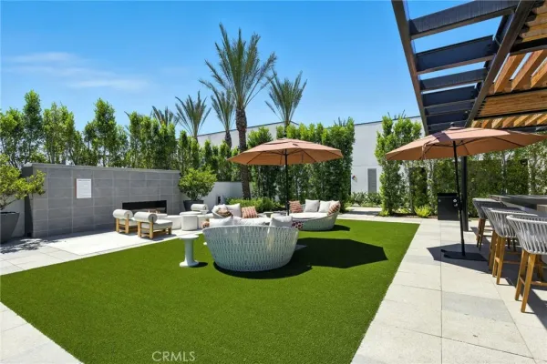 a view of a patio with table and chairs under an umbrella with a fire pit