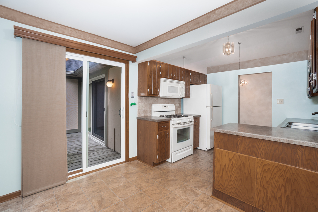 812 Meadow Ridge Lane, Unit 107 New Lenox, IL 60451 - Photo 3 of 15 a kitchen with stainless steel appliances a stove top oven a sink and a refrigerator
