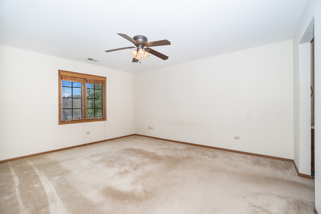 812 Meadow Ridge Lane, Unit 107 New Lenox, IL 60451 - Photo 6 of 15 a view of an empty room with a window