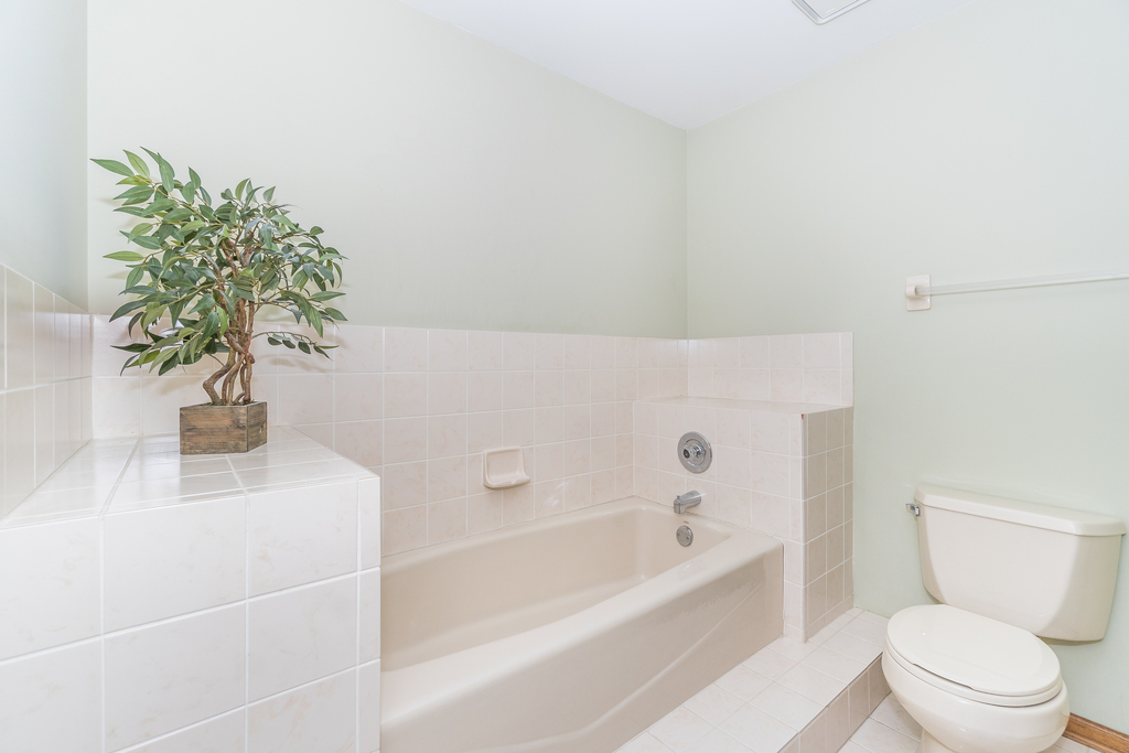 812 Meadow Ridge Lane, Unit 107 New Lenox, IL 60451 - Photo 10 of 15 a white bath tub sitting next to a white toilet
