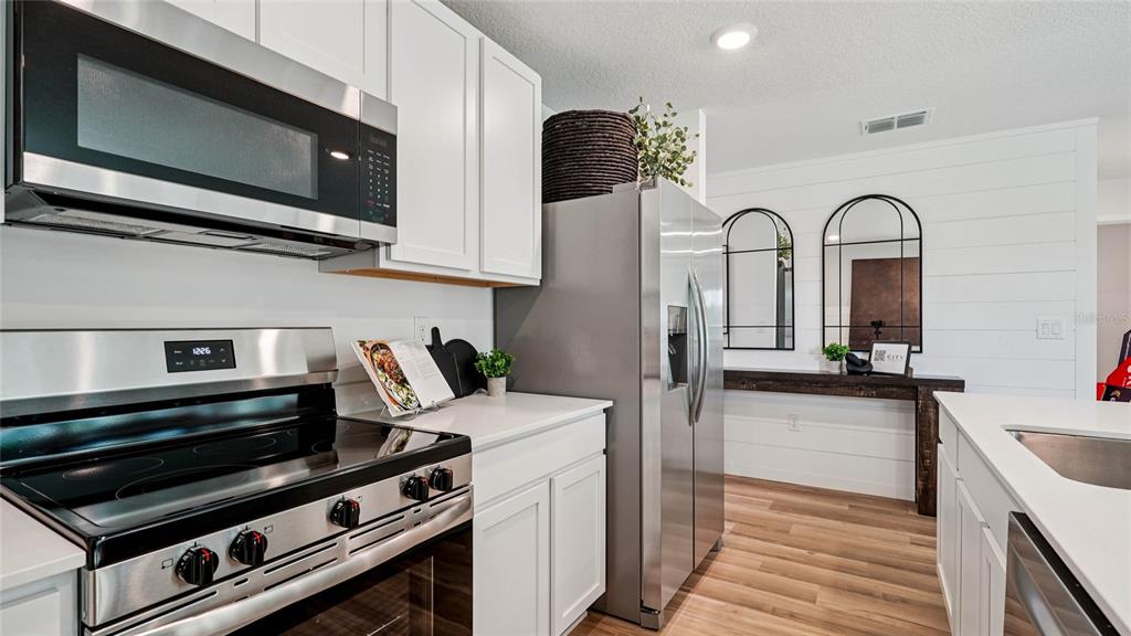 4026 Kona Circle Spring Hill, FL 34608 - Photo 5 of 26 a kitchen with stainless steel appliances a stove microwave and sink