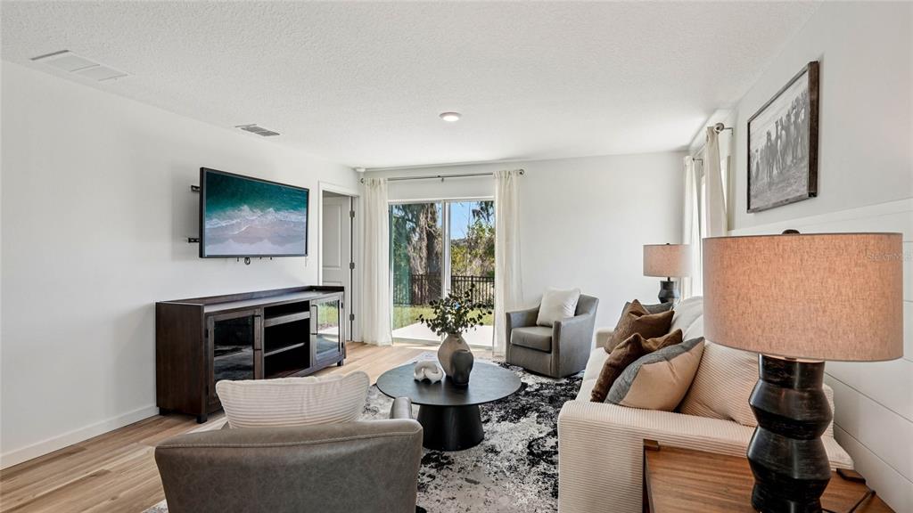 4026 Kona Circle Spring Hill, FL 34608 - Photo 10 of 26 a living room with furniture a flat screen tv and a fireplace