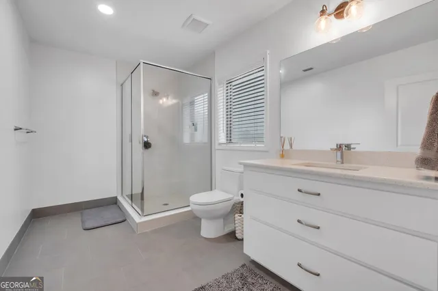 a bathroom with a double vanity sink toilet and shower
