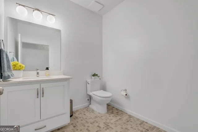 a bathroom with a sink toilet and a mirror