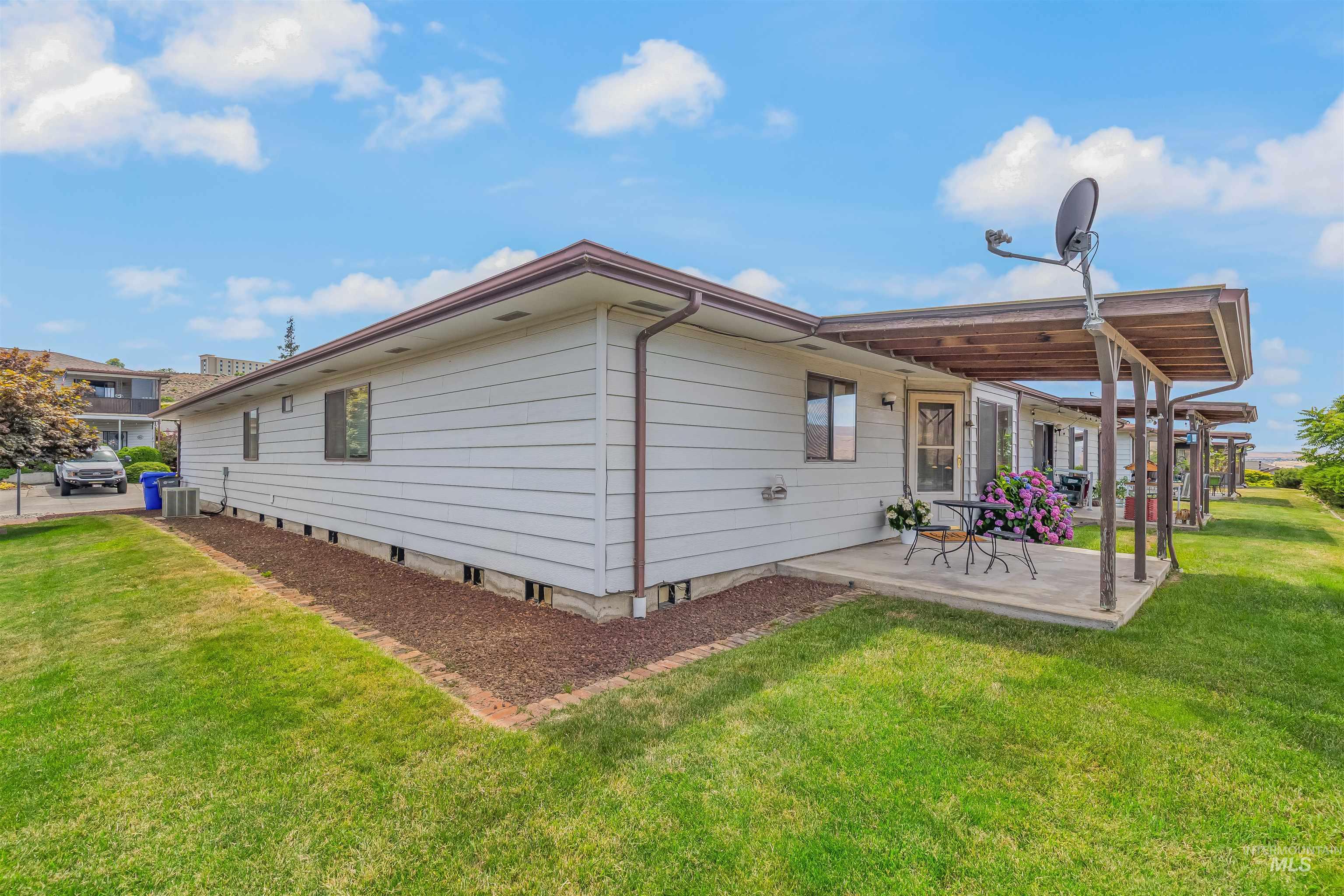 1409 29th Street Lewiston, ID 83501 - Photo 3 of 30 Rear view of property featuring a lawn and a wooden deck