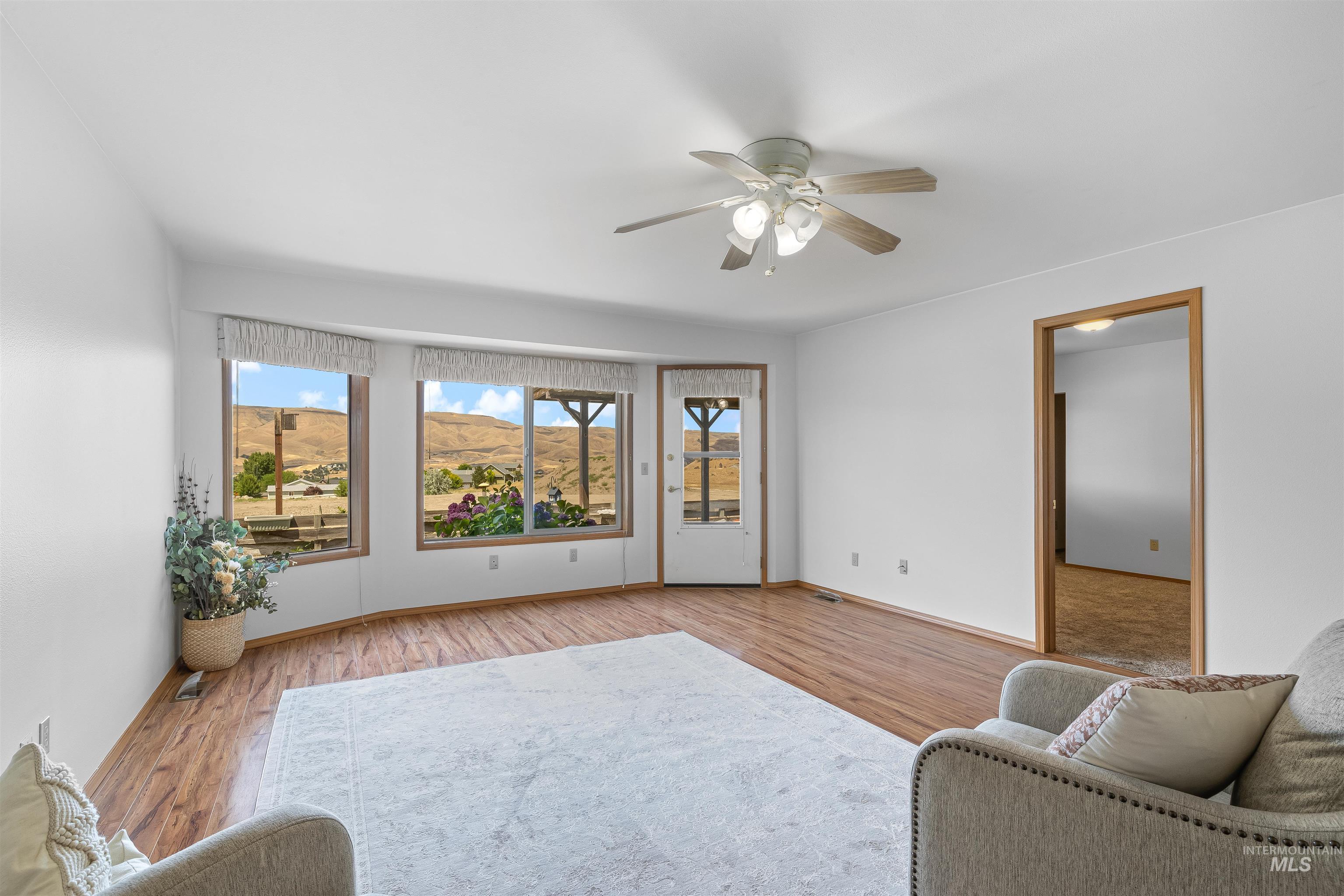 1409 29th Street Lewiston, ID 83501 - Photo 6 of 30 Living area featuring a mountain view, ceiling fan, and light wood-type flooring
