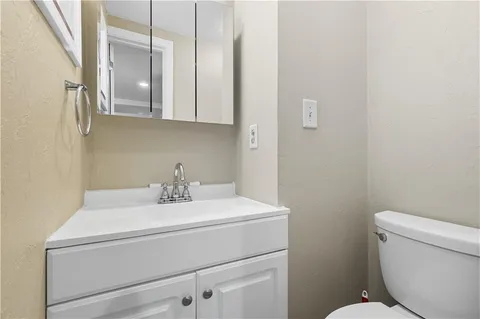 a bathroom with a sink a toilet and a mirror