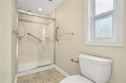 a bathroom with a shower a toilet and a shower