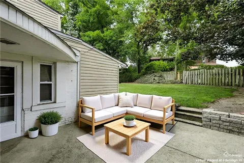 a view of a patio with couches table and chairs with potted plants and big trees