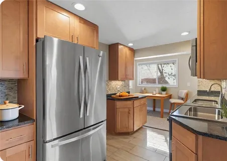 a kitchen with stainless steel appliances a refrigerator a sink a stove and cabinets