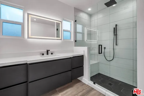 a bathroom with a shower sink and mirror