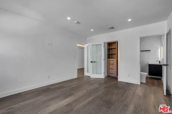 a view of empty room with wooden floor