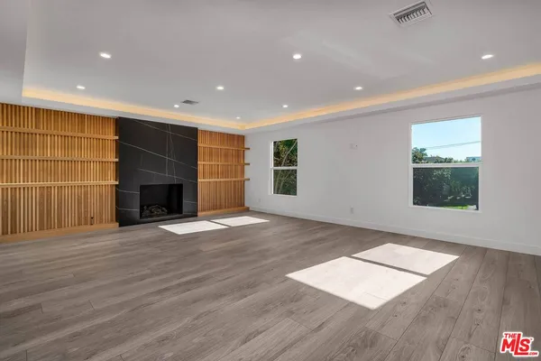 an empty room with wooden floor and fireplace