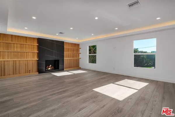 an empty room with wooden floor and fireplace