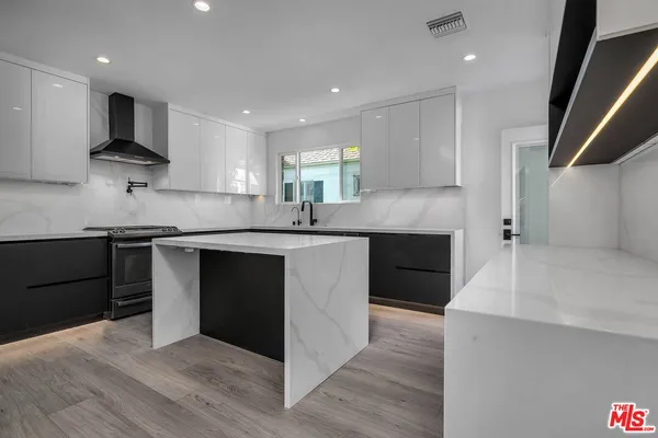 a kitchen with stainless steel appliances granite countertop a sink a stove and a refrigerator