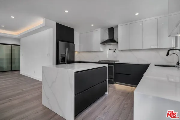 a kitchen with stainless steel appliances granite countertop a sink and a stove top oven