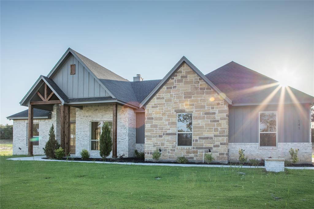 141 Prairie Winds Drive Poolville, TX 76487 - Photo 3 of 15 a front view of a house with a yard