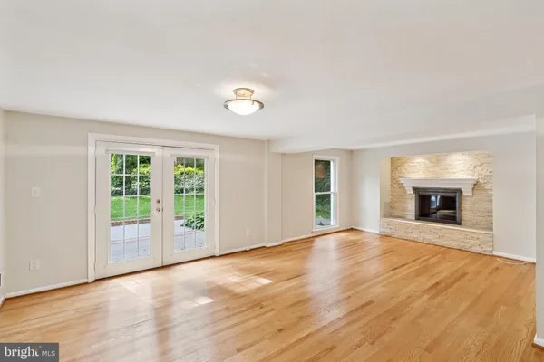 an empty room with windows and fireplace