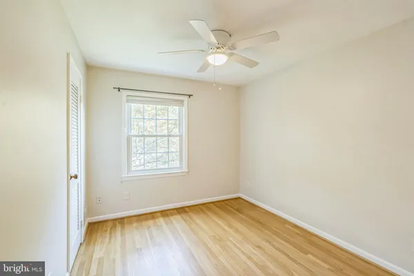 an empty room with a window and wooden floor