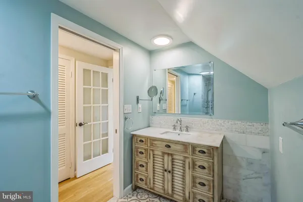 a bathroom with a shower double vanity sink and a mirror