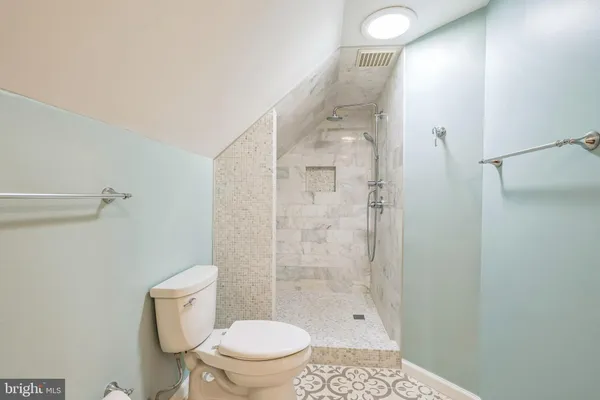 a bathroom with a shower a toilet and a window