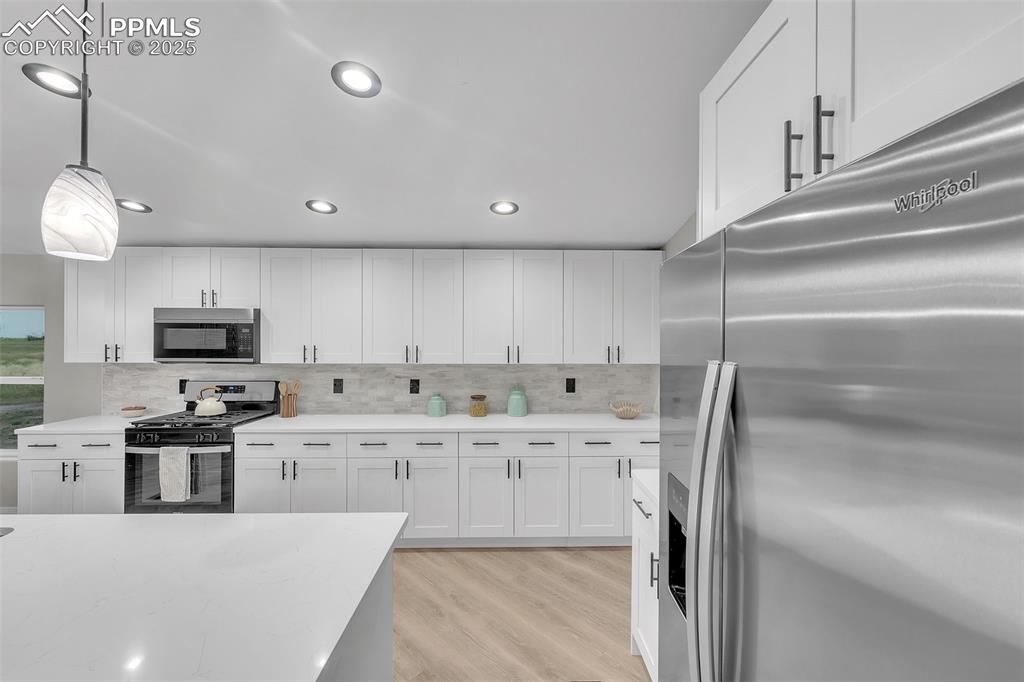 6185 Night Train Lane Yoder, CO 80864 - Photo 11 of 38 a kitchen with stainless steel appliances granite countertop a sink a stove and a refrigerator