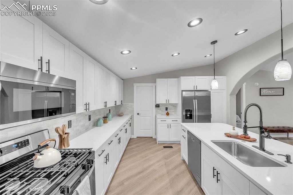 6185 Night Train Lane Yoder, CO 80864 - Photo 13 of 38 a large white kitchen with stainless steel appliances a sink a stove and cabinets