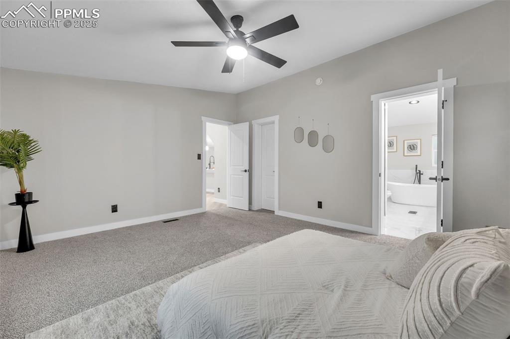 6185 Night Train Lane Yoder, CO 80864 - Photo 16 of 38 a bedroom with a large bed and a chandelier