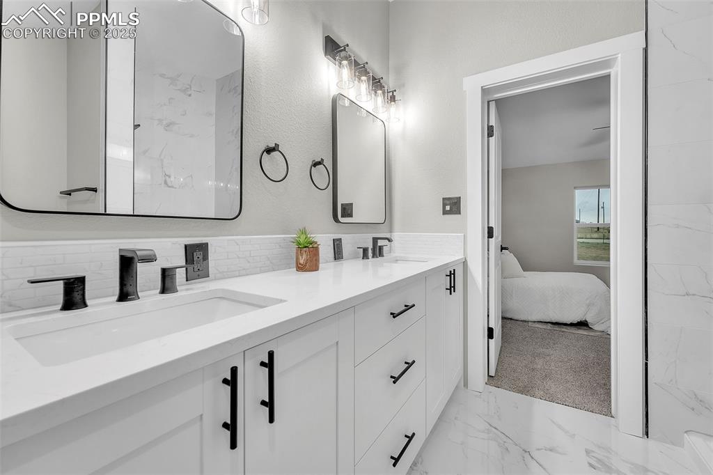 6185 Night Train Lane Yoder, CO 80864 - Photo 21 of 38 a bathroom with a double vanity sink mirror and bathtub