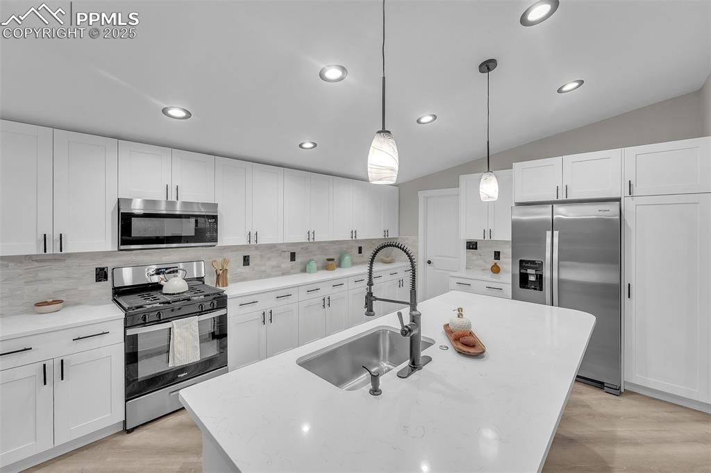 6185 Night Train Lane Yoder, CO 80864 - Photo 9 of 38 a kitchen with stainless steel appliances a sink a stove a refrigerator a center island and chairs