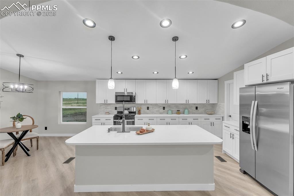 6185 Night Train Lane Yoder, CO 80864 - Photo 10 of 38 a kitchen with a sink a stove a refrigerator and cabinets