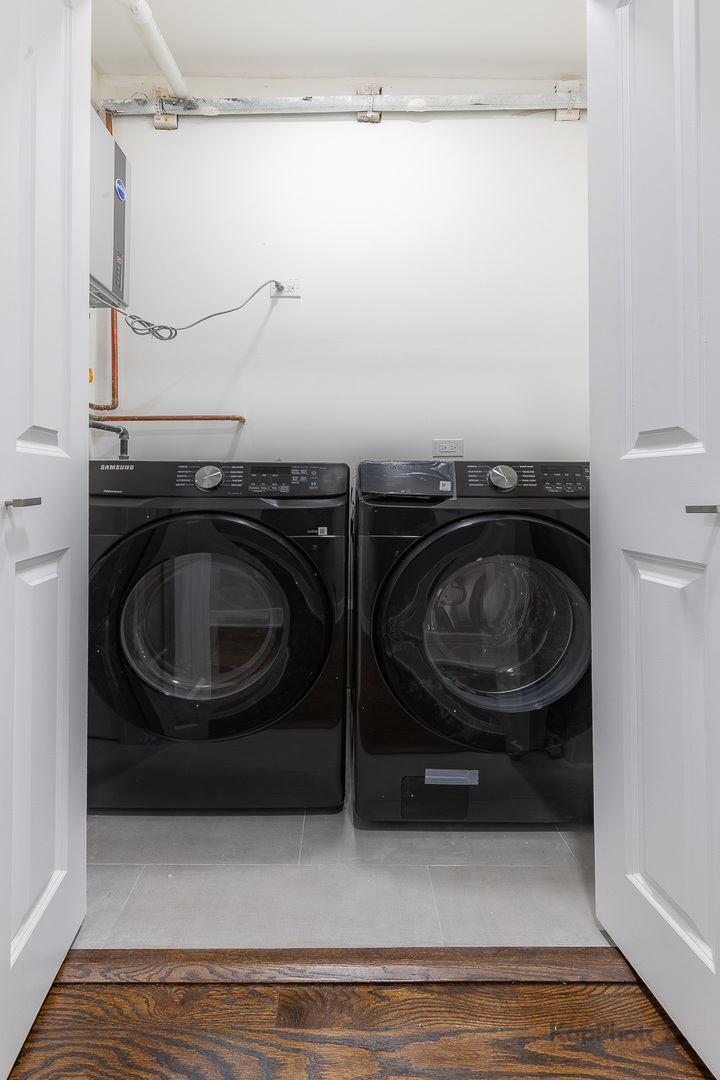 3044 West Irving Park Road Chicago, IL 60618 - Photo 25 of 37 a utility room with wooden floor and washing machine