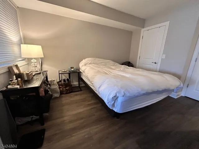 a bedroom with a bed and lamp on dresser