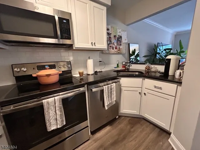 a kitchen with stainless steel appliances granite countertop a sink and a microwave