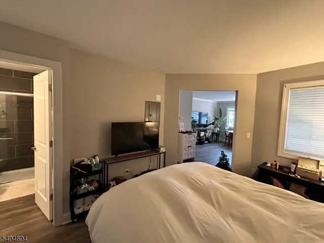 a bedroom with a bed and a flat tv screen on wall