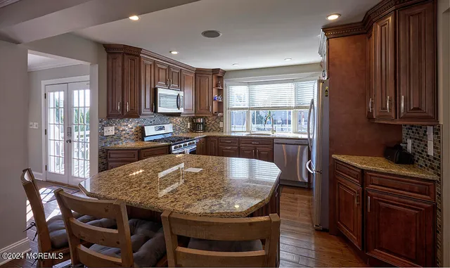 a kitchen with stainless steel appliances granite countertop a stove refrigerator and a sink
