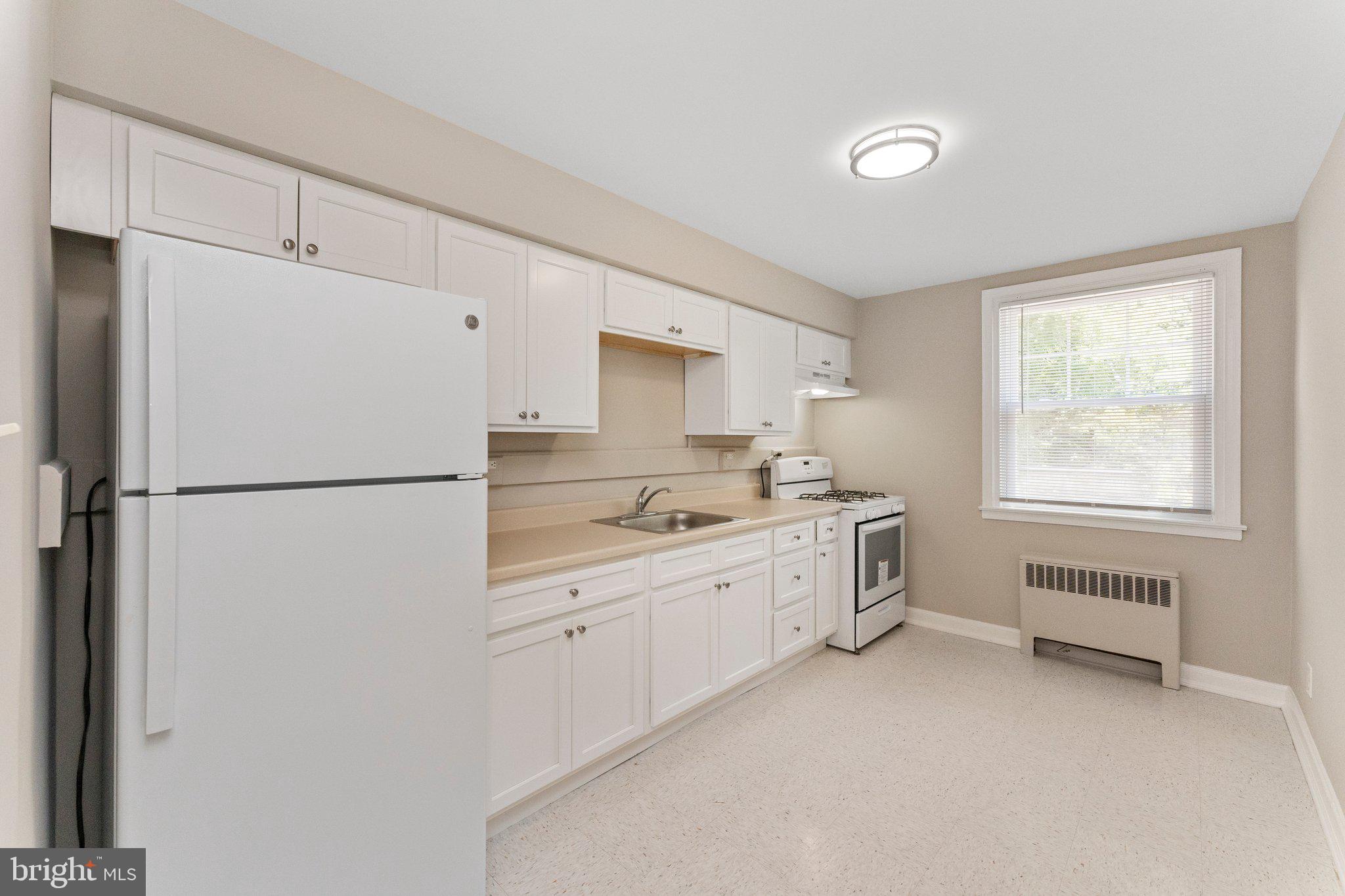 5346 Chew Avenue, Unit 2A Philadelphia, PA 19138 - Photo 10 of 17 a kitchen with a refrigerator a sink and cabinets