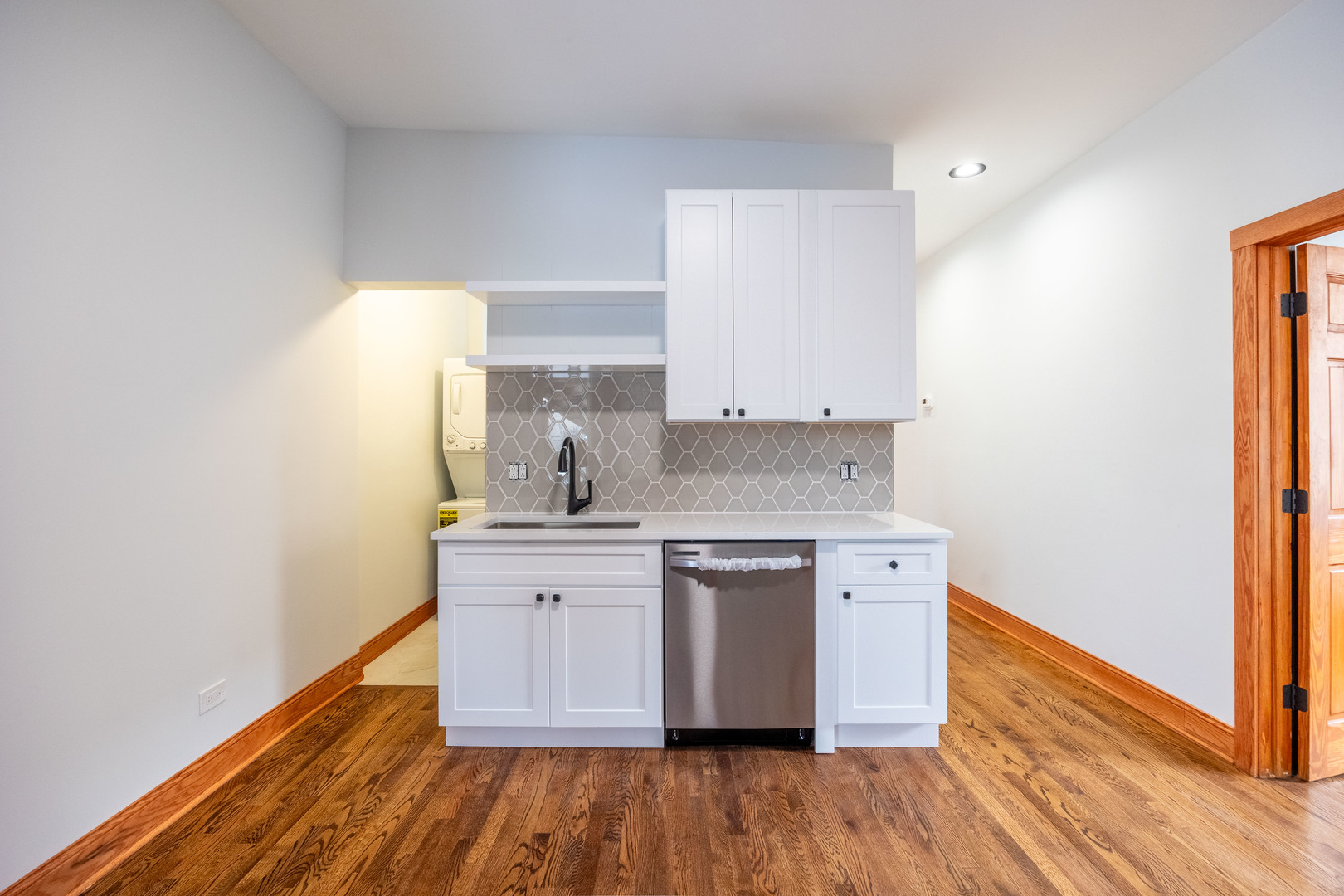 2842 West Augusta Boulevard, Unit 2E Chicago, IL 60622 - Photo 11 of 23 a kitchen with wooden floors and white cabinets