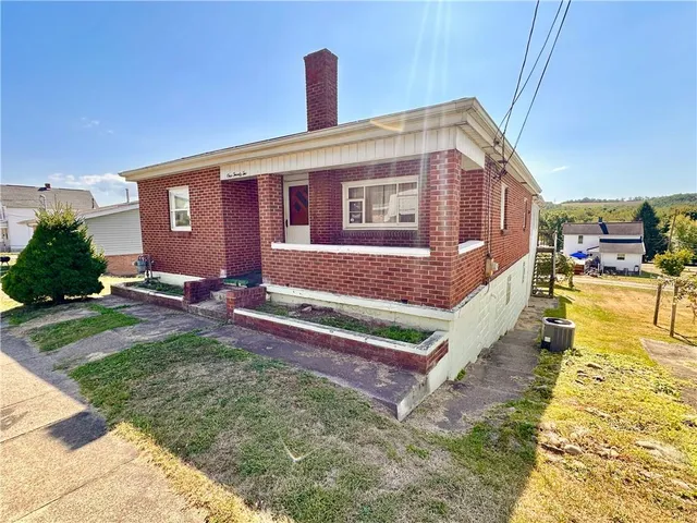 a view of a house with backyard and sitting area