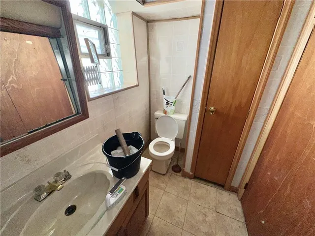 a bathroom with a sink a toilet and a mirror