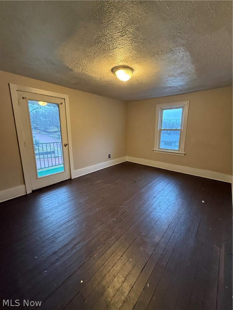 805 Carpenter Street Akron, OH 44310 - Photo 3 of 8 Unfurnished room featuring dark wood-style flooring and a textured ceiling